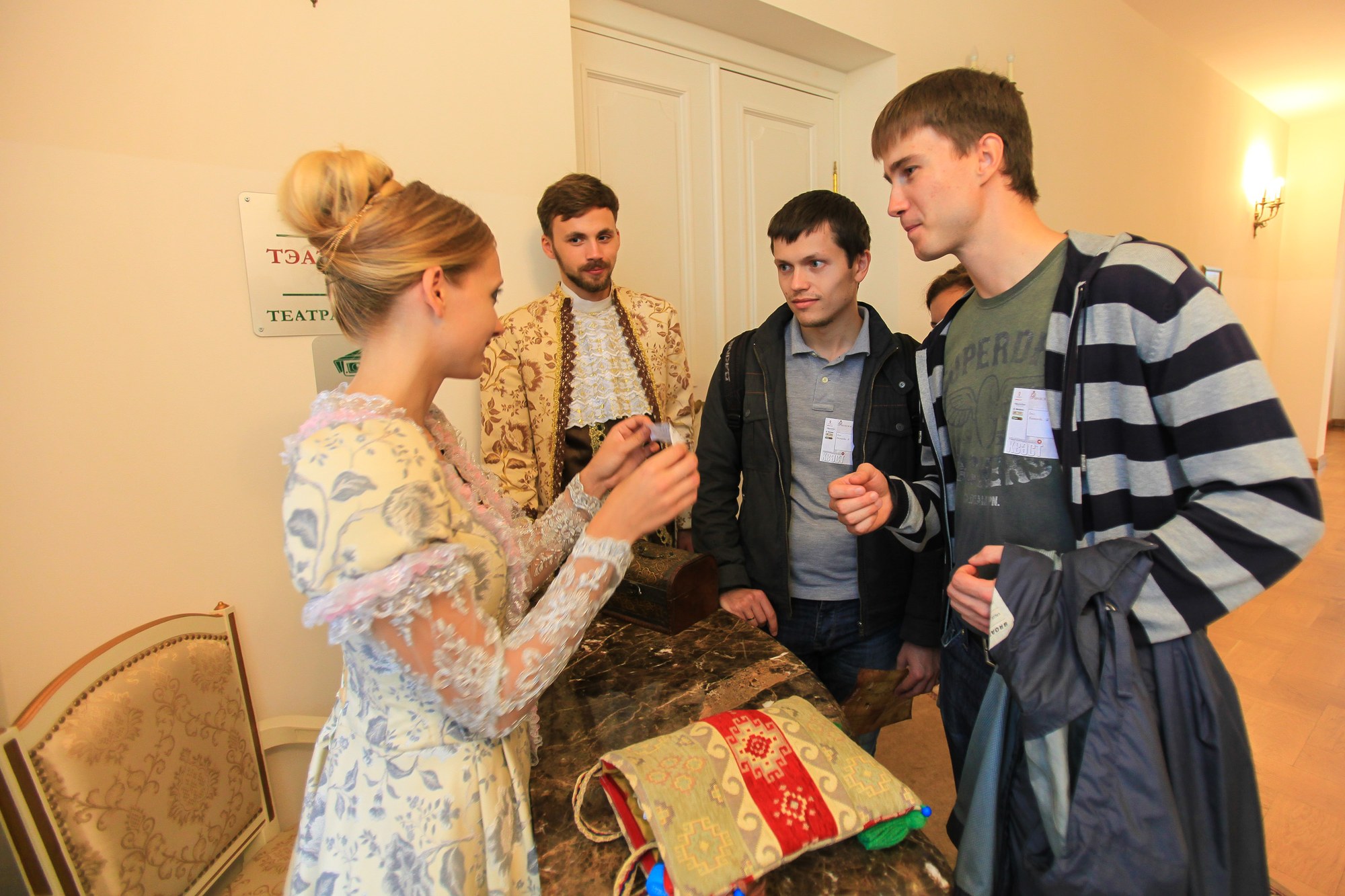 Актеры в шляхетских нарядах принимают выполненные задания в театральном зале