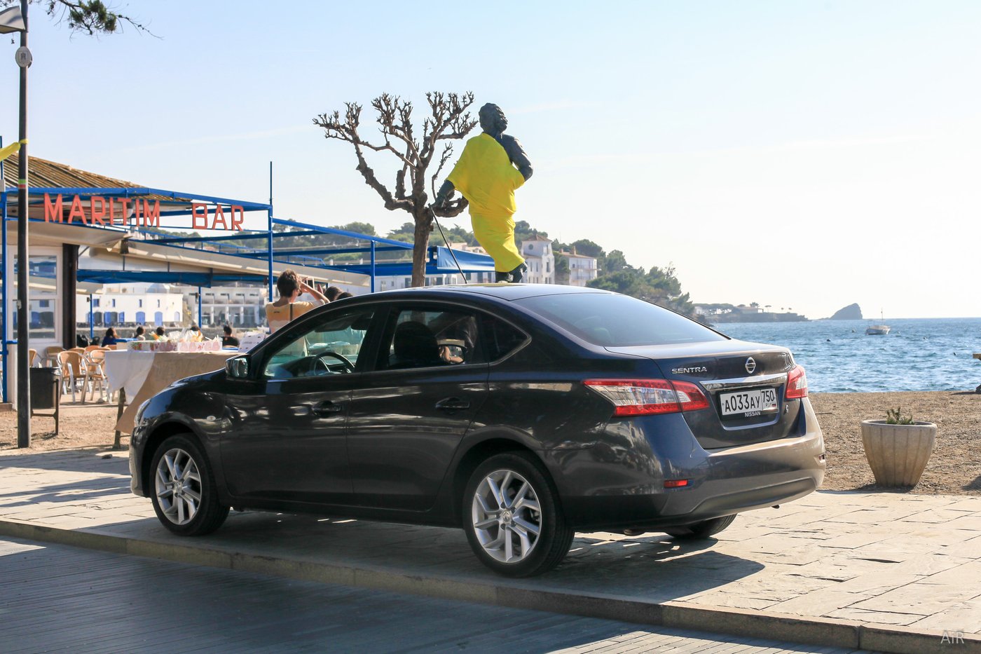 Nissan Sentra на набережной Кадакеса рядом со скульптурой Сальвадора Дали